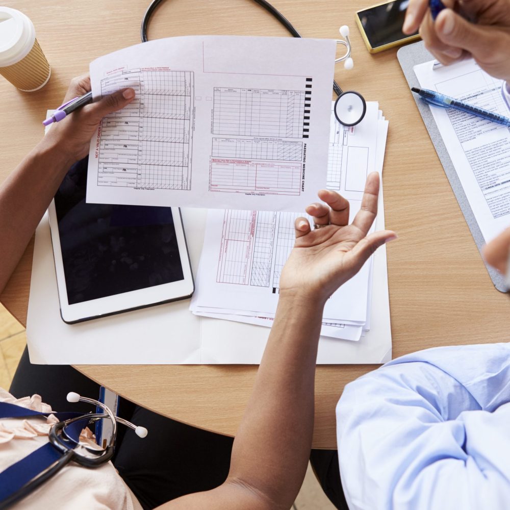 Overhead shot of doctors in consultation over patient notes